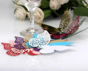 Detailed macro view of laser-cut butterfly place cards in various colors for weddings