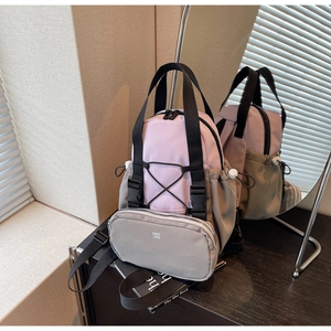 Detail of pink and grey outdoor backpack with criss-cross elastic cords and logo