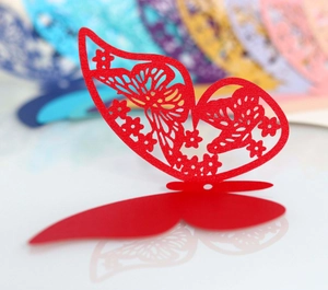 Macro detail of laser-cut red butterfly card with 3D folding structure and floral pattern
