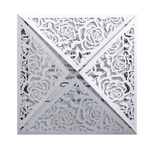 Detailed laser cut white floral invitation sleeve featuring a hollow rose pattern and card