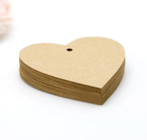 Κοντινή λήψη από καρτελάκια δώρου σε σχήμα καρδιάς από χαρτί κραφτ με προτρυπημένες οπές