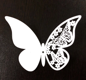 White 3D hollow butterfly wall sticker with intricate laser cut floral pattern on wood