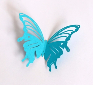 Detail of 3D blue hollowed-out butterfly paper decoration with intricate laser-cut wings