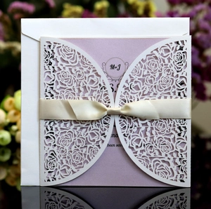 Elegant laser-cut white rose wedding invitation with lavender insert and silk bow