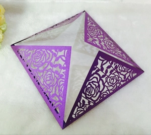 Macro detail of purple laser cut paper invitation cover with intricate rose pattern