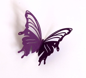 Detailed close-up of a 3D purple laser-cut paper butterfly with intricate hollow patterns
