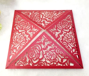Detail of red square laser-cut wedding invitation featuring intricate rose flower patterns