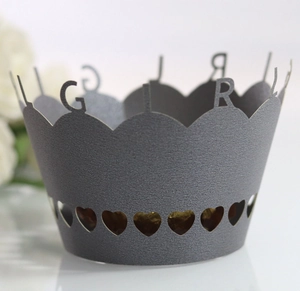 Macro detail of laser-cut cupcake wrapper featuring GIRL lettering and heart patterns