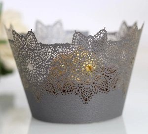 Detailed macro of laser-cut silver lace cupcake wrappers with elegant pearl finish