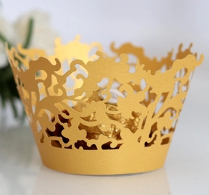 Elegant gold laser-cut lace cupcake liner with intricate vine pattern for party decor