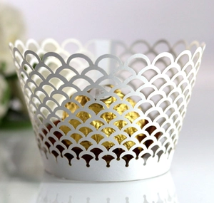 Macro detail of laser-cut white cupcake wrapper featuring elegant fish scale pattern