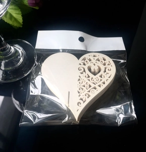 Macro view of laser-cut heart-shaped wooden gift tags with intricate scroll patterns