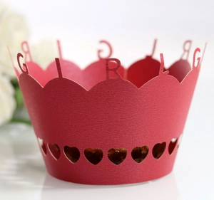 Close-up of red laser-cut cupcake wrapper featuring GIRL text and heart-shaped hollow patterns