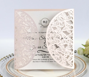 Macro shot of laser cut butterfly wedding invitation with delicate pearlescent paper details