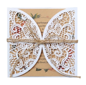 Detail of laser-cut butterfly wedding invitation with rustic twine and floral kraft insert