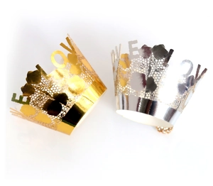 Macro detail of laser-cut LOVE flower lace cupcake wrappers in metallic gold and silver