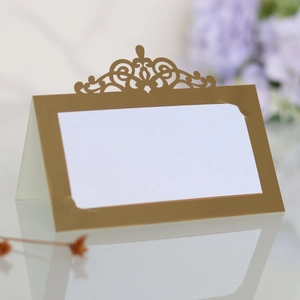 Détail macro du marque-place doré découpé au laser avec motif de couronne élégant sur table