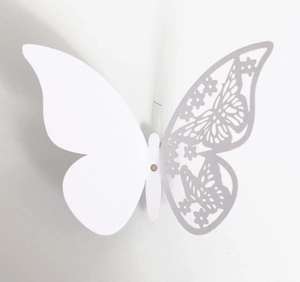 Detail of 3D laser-cut white butterfly wall sticker with intricate hollowed flower patterns