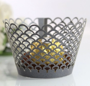 Close-up of laser-cut silver pearl paper cupcake wrappers with fish scale hollow pattern