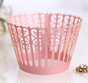 Close-up of pink laser-cut lace cupcake wrapper with intricate pearlescent heart details