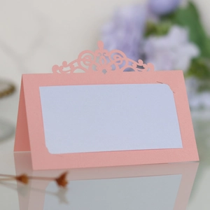 Détail du marque-place rose découpé au laser avec motif ajouré et papier perlé chic