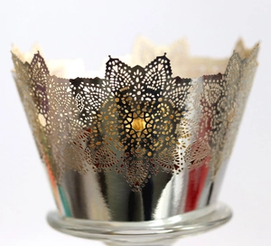 Macro shot of silver lace laser-cut hollow cake wrapper with intricate floral details