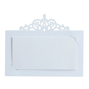 Détail de marque-place découpé au laser avec motifs de volutes pour mariage chic