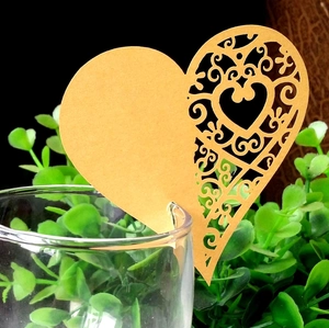 Close-up of heart-shaped laser-cut place cards on a glass for wedding decor