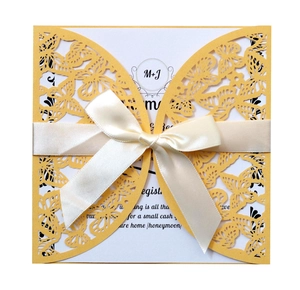 Detailed laser-cut butterfly invitation cover with elegant white satin ribbon and bow