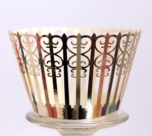 Laser-cut gold hollow cupcake wrapper with elegant wave patterns and metallic finish