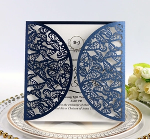 Detail showing navy blue laser-cut butterfly wedding invitation with white pearl paper insert