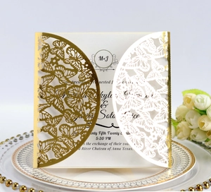 Macro detail of laser-cut butterfly invitation card with elegant gold hollow pattern