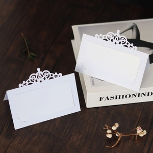 Marque-place de mariage blanc découpé au laser avec arabesques sur fond en bois chic