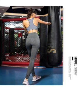 Vista posteriore di leggings yoga grigi a vita alta con design modellante in palestra