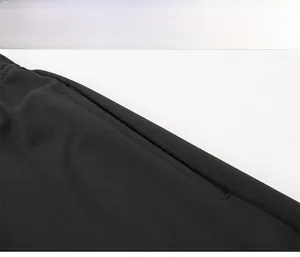 Détail de la poche invisible renforcée et coutures denses sur le pantalon de sport noir