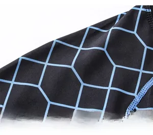 Close-up of moisture-wicking fabric with blue geometric patterns and flatlock stitching