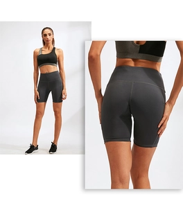 Detail of high-waisted gray yoga shorts with side pockets and racerback sports bra