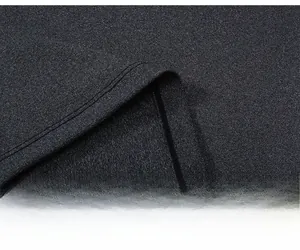 Close-up of double-stitched hem and gray textured fabric on women's athletic yoga shirt