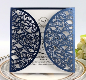 Detail of laser-cut navy blue wedding invitation with butterfly texture and white insert