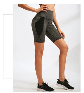 Dettaglio di pantaloncini da yoga grigi a vita alta con tasche a rete e tessuto tecnico