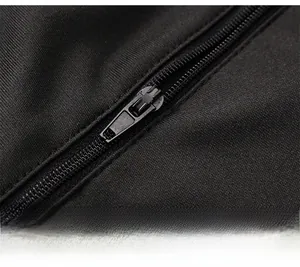 Dettaglio della cerniera in metallo nero opaco sui pantaloni sportivi con tasca con zip