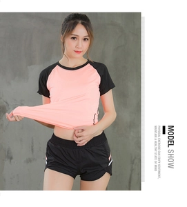 Detail showing elastic stretch of pink and black color-block sports short sleeve top