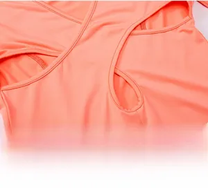 Vue détaillée du haut de yoga rose corail avec bretelles croisées au dos et découpe ajourée