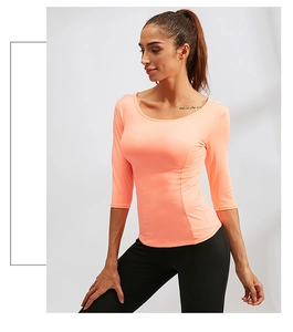 Détail d'un haut de yoga rose ajusté avec tissu extensible à séchage rapide pour femme