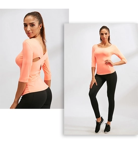 Détail du haut de yoga orange corail à manches longues avec dos croisé ouvert