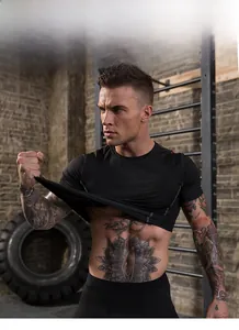 Men's athletic compression shirt showing high elasticity and quick-dry fabric in gym