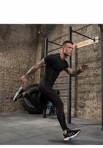Male athlete running in black compression gym suit with red and grey line details