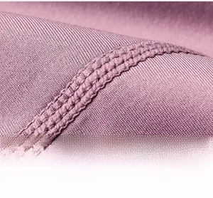 Detailed macro view of the mauve high-stretch fabric with professional double stitching