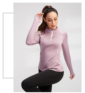 Detail of purple long sleeve sports top with white half-zipper and thumb holes design