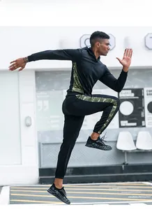 Dynamic view of men's black camouflage sports hoodie and joggers set during running action